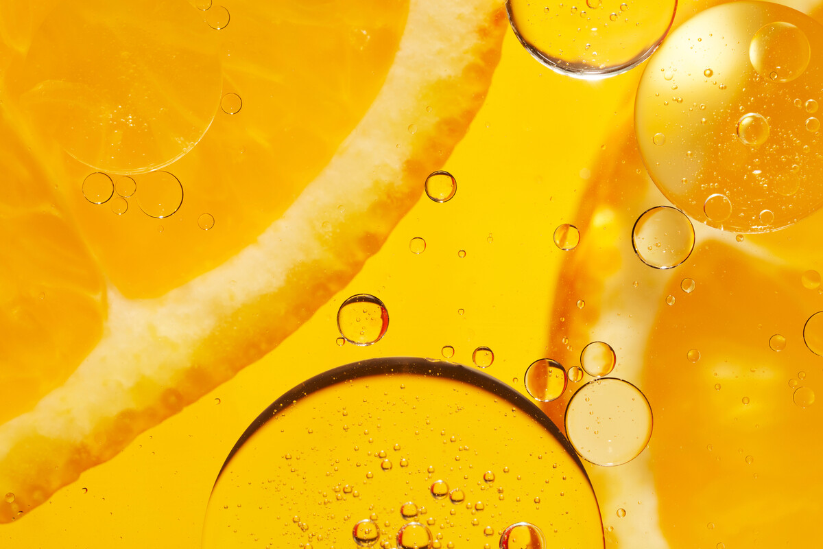 A close up of orange in an orange coloured liquid.
