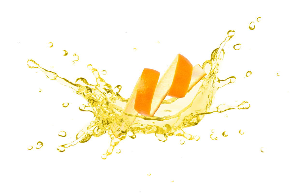 A peeled rind of an orange citrus fruit, surrounded by a splash of liquid.