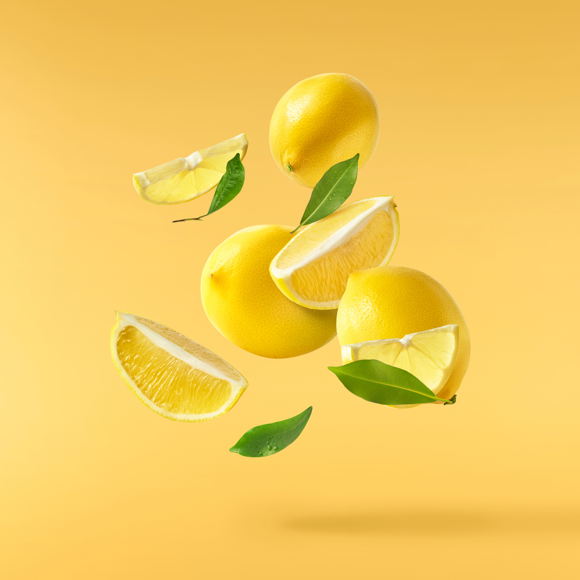 A stylised depiction of both full and sliced lemons, floating in the air, along with a few leaves.